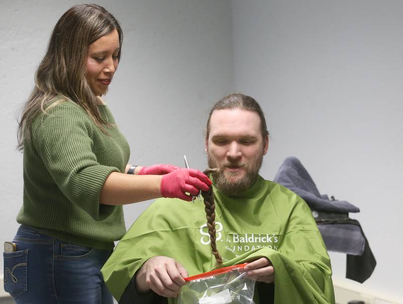 Beautician Erika Reyes, removes a lock of hair from shavee Toren Martin of Mendota, during the first ever St. Baldrick's event on Wednesday, April 30, 2025 at Illinois Valley Community College. This was Martin's first hair cut in over 5 years.