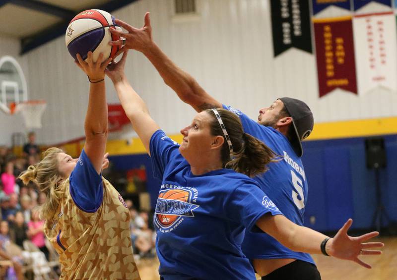 Larissa Pinter. Physical Education instructor at Logan Jr. High School, Brittany Sledgister Douglas School paraprofessional and Joey Horn, principal at Lincoln School jump for the ball at the same time during the Harlem Wizards event on Tuesday, Oct. 28, 2025 in Pannebaker Gymnasium at Logan Jr. High School in Princeton.