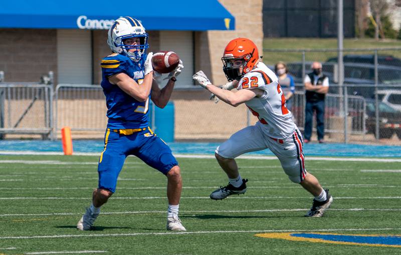 Wheaton North's Gabe Parker (3) catches a pass against Wheaton Warrenville South's Conor Cunningham (22) during a football game in Wheaton April 3