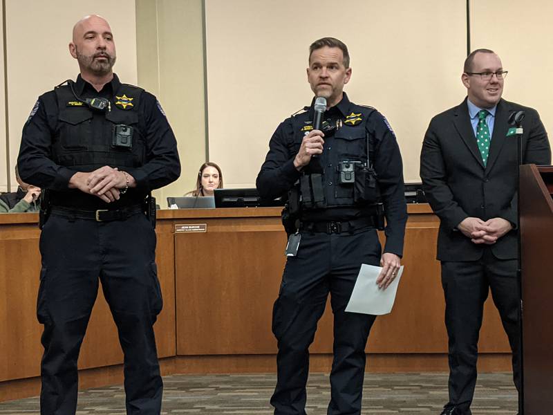 Oswego Police Chief Jason Bastin, middle, and Oswego Village President Ryan Kauffman, right, honor retiring Oswego Police Deputy Chief Chris Biggs, left, during the Dec. 10 Oswego Committee-of-the-Whole meeting.