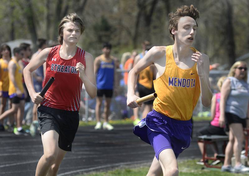 Streator’s Ciab Reed and Mendota’s Jacob Carr compete in the 4x800 relay during the Rollie Morris Invite on Saturday, April 15, 2023 at Hall High School.