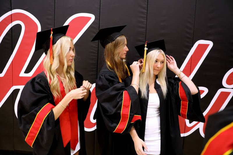 Batavia High School graduates Teagon Rokos, Mason Matysik and Lindsay Fehrenbacher adust their caps before the school’s 2025 commencement ceremony on Wednesday, May 21, 2025 at Northern Illinois University in DeKalb.