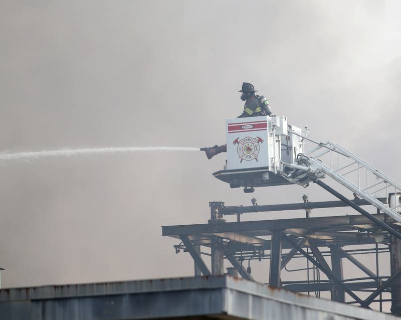 A Peru firefighter attacks the flames and smoke from above at Carus Chemical on Wednesday, Jan. 11, 2023 in La Salle.