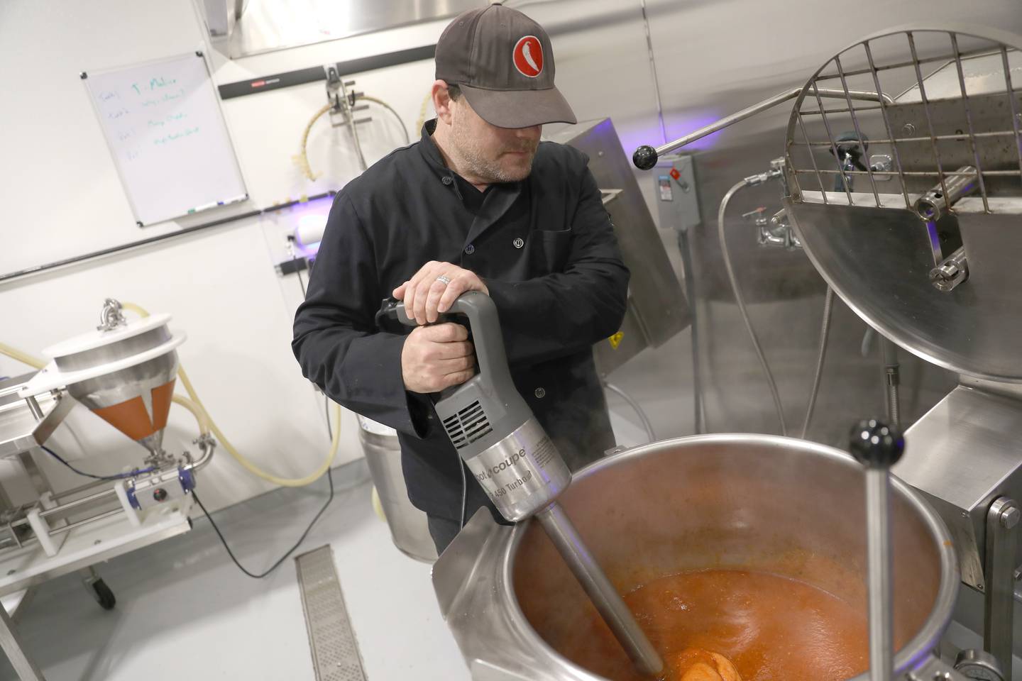 Chris Ginder makes a new batch of hot sauce in the kitchen of the Gindo’s Spice of Life St. Charles headquarters. Gindo’s owners Chris and Mary Ginder each won awards recently from the Small Business Association.