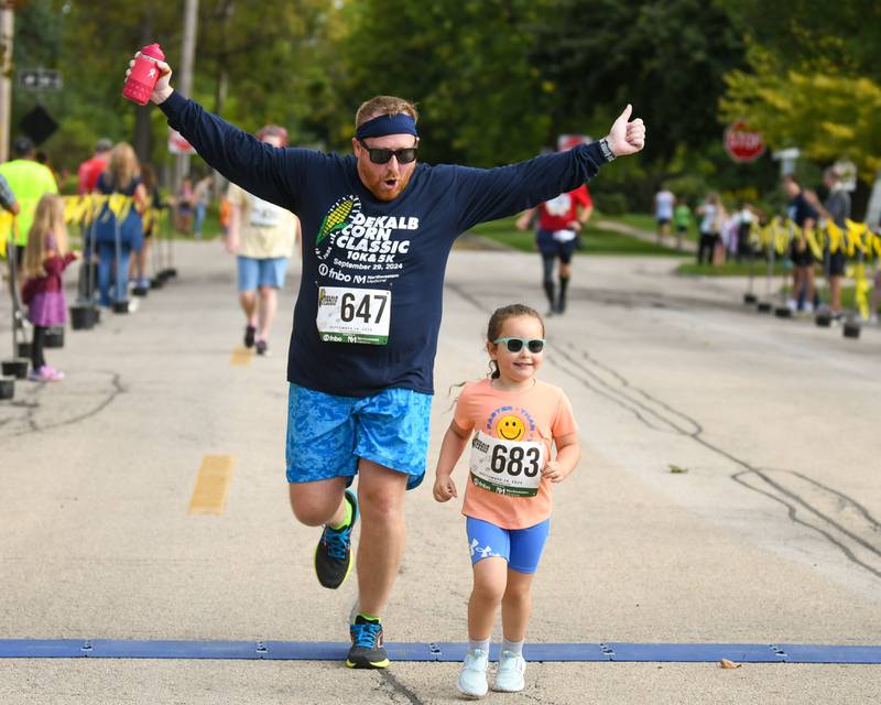 Eric Sauld celebrates as he and M. Sauld cross the finish line during the DeKalb Corn Classic 5K/10K race on Sunday, Sept. 29, 2024, held downtown.
