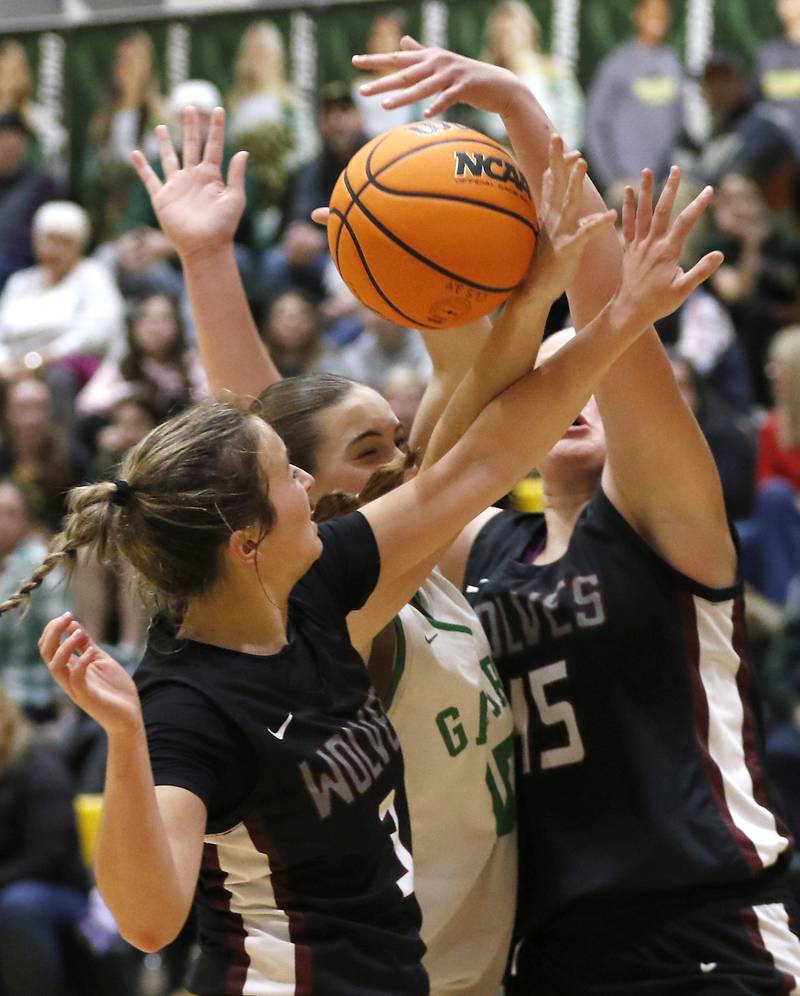 Prairie Ridge's Zoe Nanos (right) and Jenna Albanese (right) battle with Crystal Lake South's Tessa Melhuish (center) for a rebound during a Fox Valley Conference girls basketball game on Friday, Dec. 13, 2024, at Crystal Lake South High School.