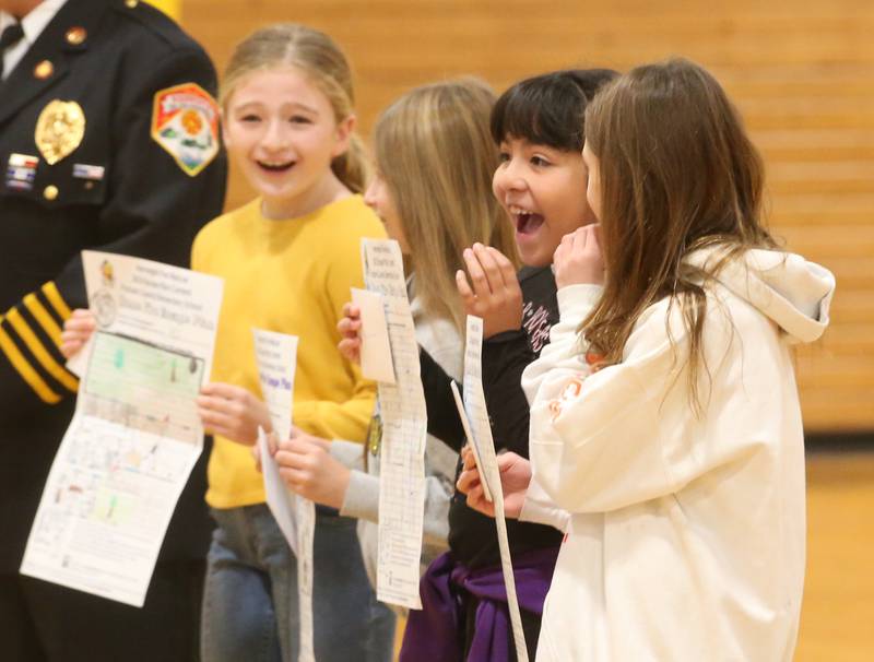 Putnam County Elementary students Priscilla Serna and Octavia Walter react when winning the Hennepin Fire Department Escape Floor plan contest on Tuesday, Nov. 21, 2023 at Putnam County Elementary School in Hennepin. Students had to draw a floor plan or map of their home showing all doors and windows. Smoke alarms had to be marked in each plan. A family meeting place was also required to be marked on the drawings. The Hennepin Fire Department has been holding the contest for several years. The department stopped the event during Covid and continued it for the first time since the pandemic this year. The department picks the winning children up on a firetruck and busses them to school .