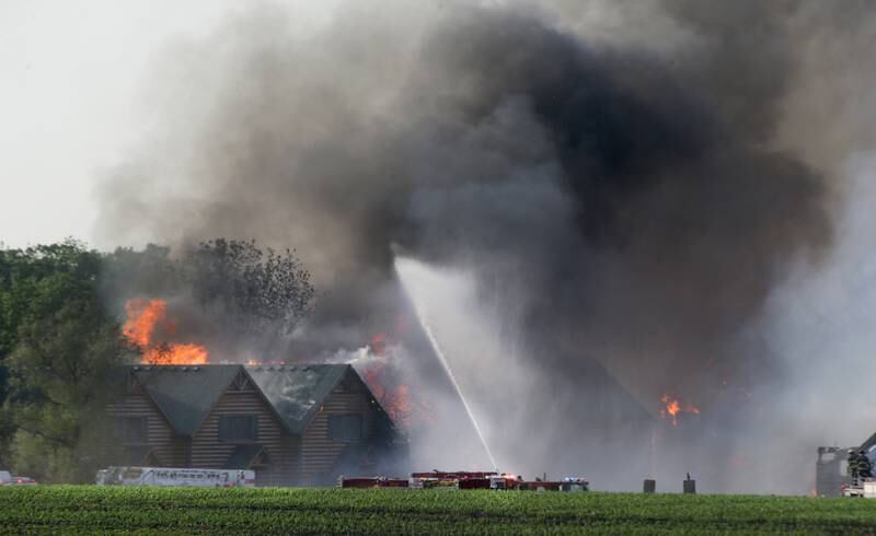 Flames emit from several cabins Monday, May 30, 2022, at Grand Bear Resort as firefighters work to extinguish the blaze. Strong winds pushed the flames to neighboring cabins.