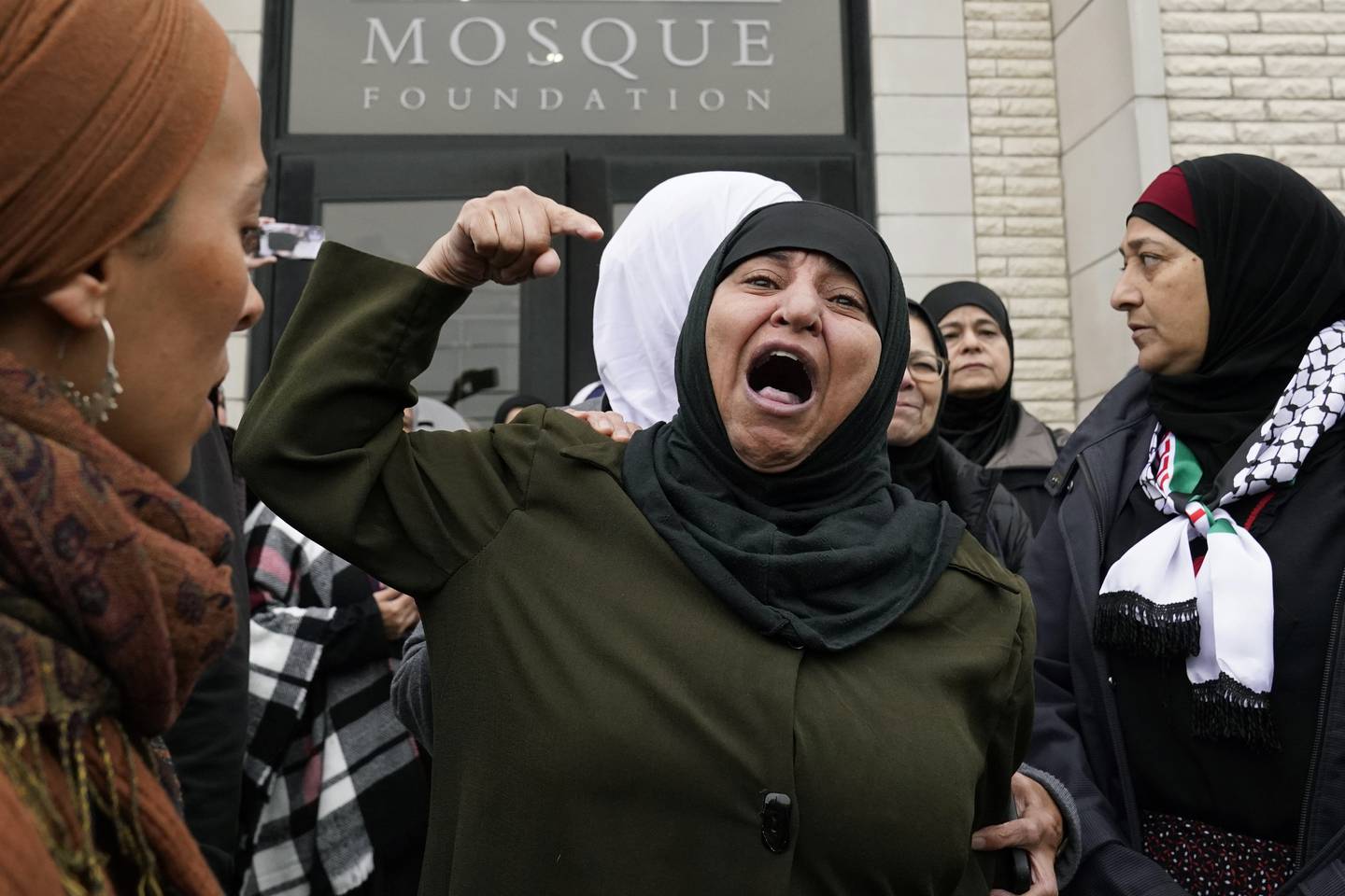 A Muslim community member shouts into the crowd for Wadea Al Fayoume at Mosque Foundation in Bridgeview, Ill., Monday, Oct. 16, 2023.