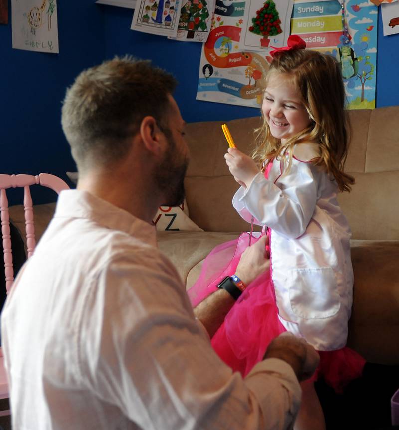 Everly Backe, 4, who has had multiple open heart surgeries to correct congenital heart defects, plays with a doctor Friday, Feb. 11, 2022, with her father, Matt Backe, in their Crystal Lake home. As Everly has became more aware of her chest scar, which they call her "zipper," her dad recently decided to get a tattoo that matches his daughter’s scar from her surgeries so she does not feel alone in having the scar.