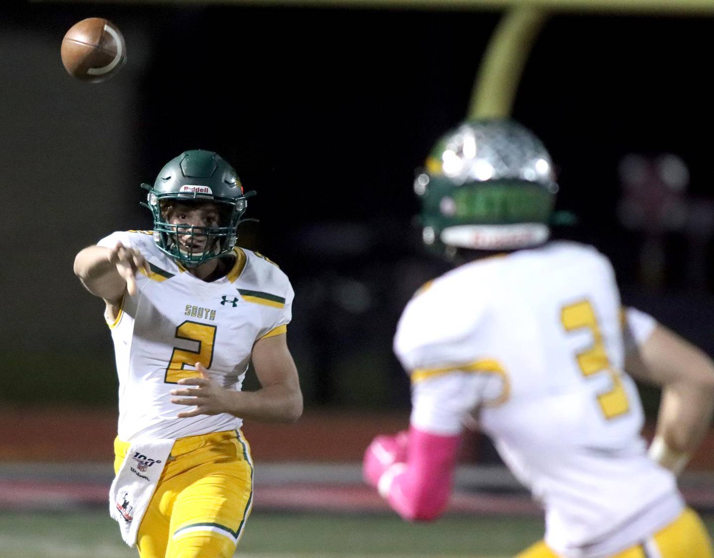 Crystal Lake South’s Caden Casimino, left, tosses to Colton Hess in varsity football action at Huntley Friday evening.