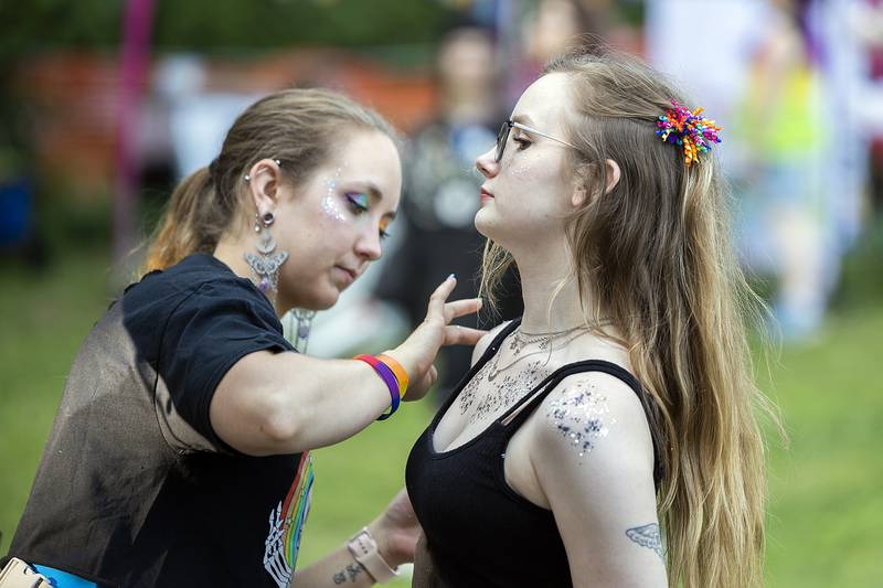 Chasity Carroll (left) applies body glitter to Mikaila Oros Saturday, June 14, 2025, during Sauk Valley Pride Fest in Dixon.