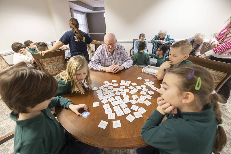 Morningside of Sterling resident Bill Widolff plays a game with St. Andrew’s students Ruthie (left), Tino, Brynlee and Camden Thursday, Jan. 30, 2025, at the senior living facility. Before playing the games, the kids sang several songs for the residents.