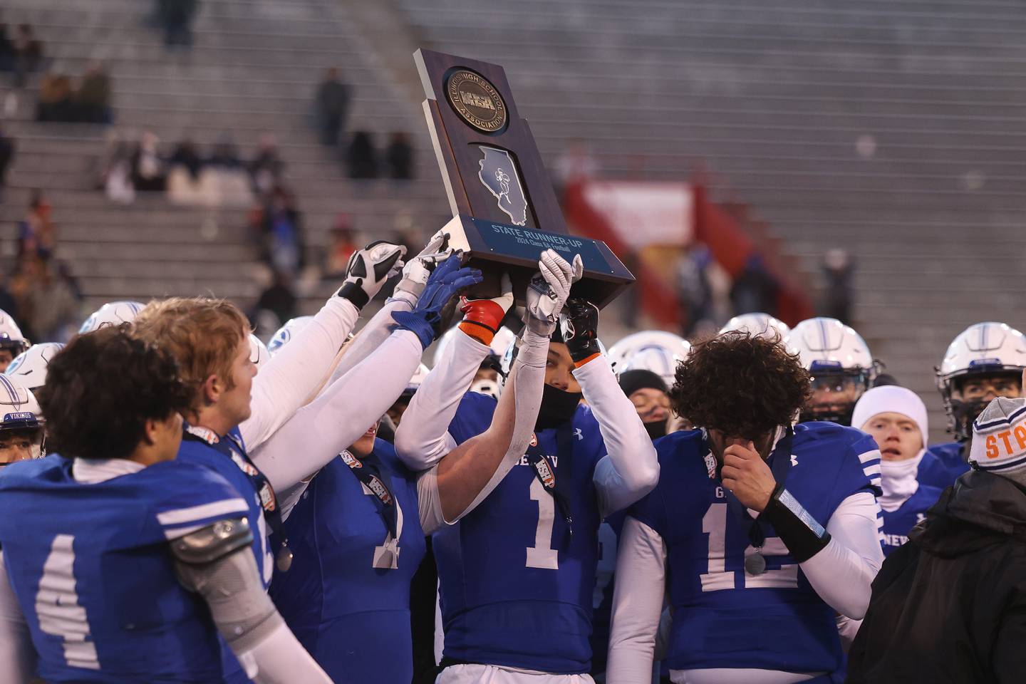 Geneva holds up the 2nd place trophy after losing to East St. Louis 48-28 in the Class 6A state championship on Saturday, Nov. 30, 2024 in Normal.