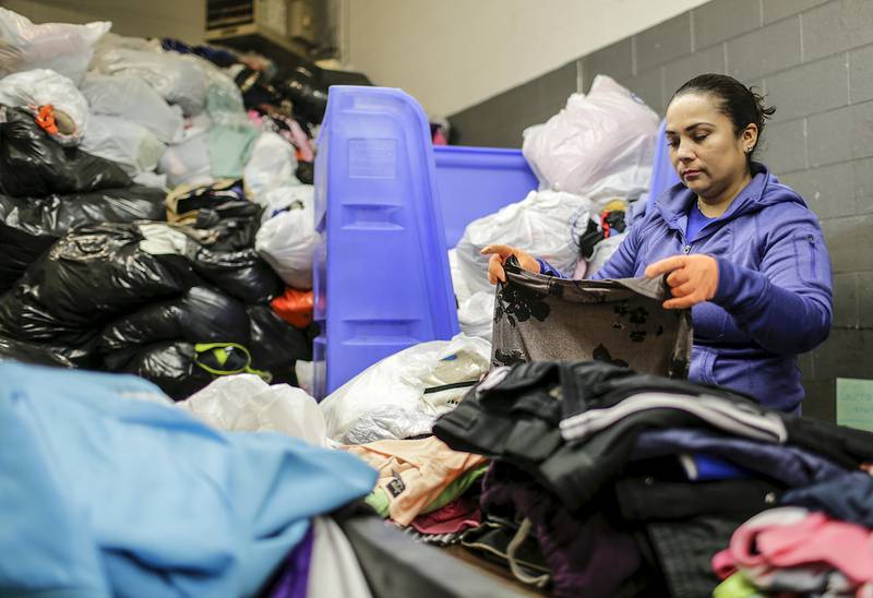 Luz Garibay sorts through bags of donated clothes April 23 at the St. Vincent Family Thrift Store in Joliet.