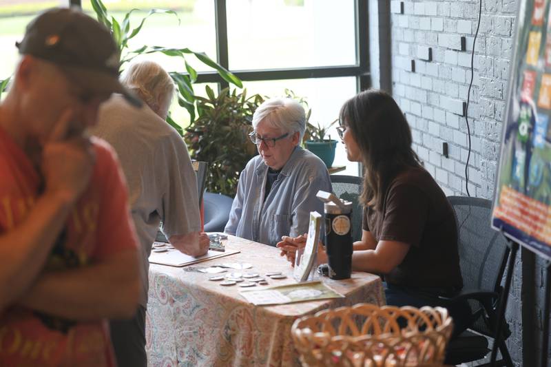 A resident puts their name on a mailing list at one of the many tables promoting the environment at the Green Escape Earth Day Event on Wednesday, April 22, 2026 in Joliet.