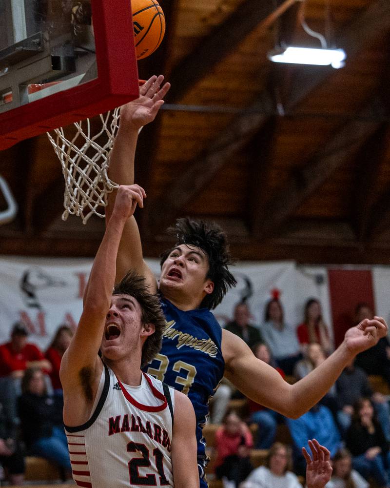 Henry-Senachwine's Carson Rowe (21) lays up ball as Marquette's Blayden Cassel (33) blocks shot against backboard on Friday, Feb. 13, 2026 at Henry-Senachwine High School in Henry.