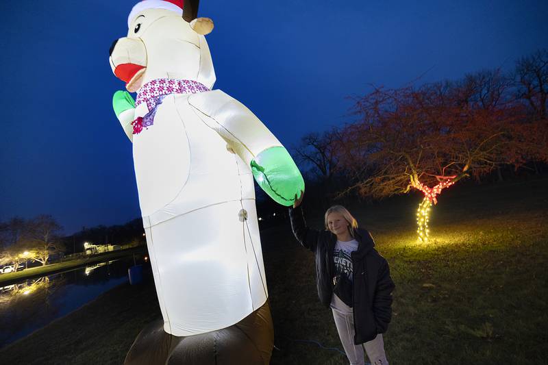 Aubree Boss, 13, holds hands with a giant Rudolph Tuesday, Nov. 26, 2024, at Centennial Park. Boss was helping decorate Boss Roofing’s lighted display in Rock Falls.