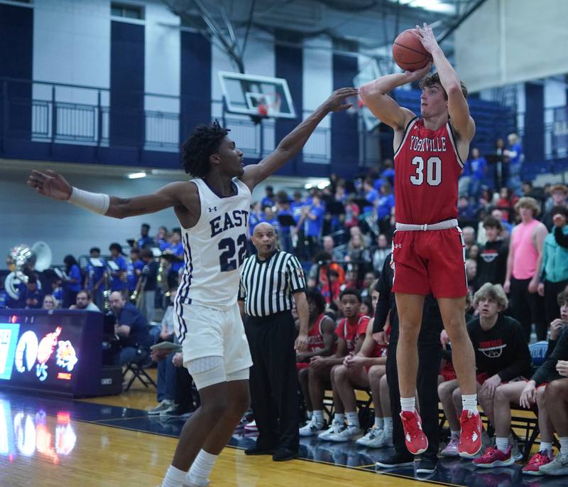 Yorkville's Bryce Salek (30) shoots a three pointer against Oswego East's Jehvion Starwood (22) during a basketball game at Oswego East High School on Friday, Dec 8, 2023.