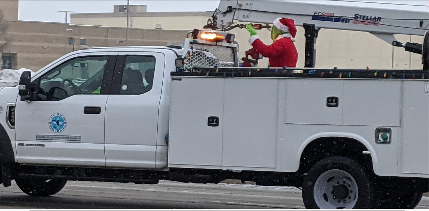 The Grinch waves to those watching the Santa Send-Off Parade as it travels past Plainfield South High School on Saturday, Dec. 13, 2025.
