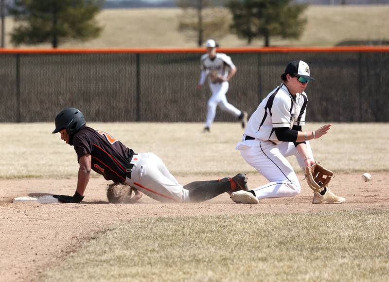Sycamore's Nathan Lojko takes the throw as Byron’s Jekyven Edmonson slides in safely with a stolen base during their game Wednesday, March 26, 2025, at DeKalb High School. Sycamore’s home field was damaged in last week’s storms so today’s game was played on DeKalb’s field.