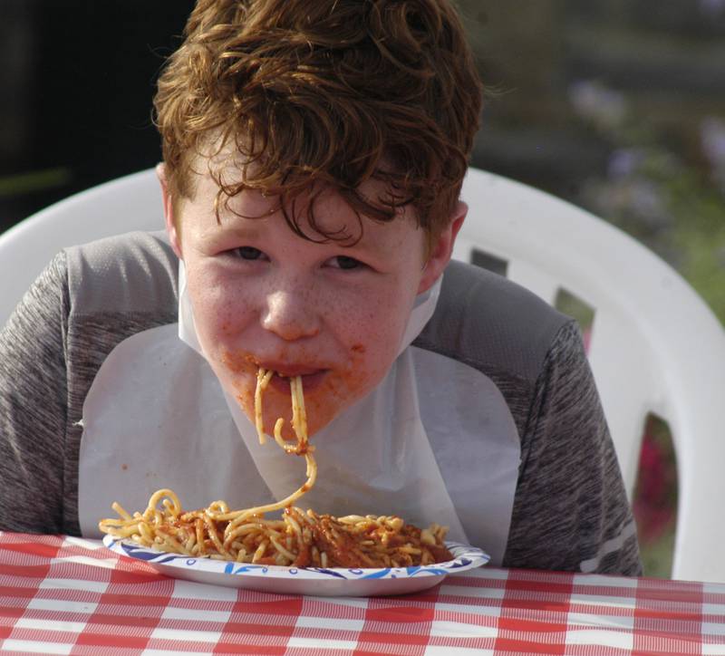 Carter Hubbell of Franklin Grove works hard in the spaghetti eating contest at Venetian Night. Venetian Night in Dixon featured magicians, street performers, face painting, a spaghetti eating contest, mini boat races, and a drone light show. The Discover Dixon event was held along the riverfront in Dixon on Aug. 9, 2025.