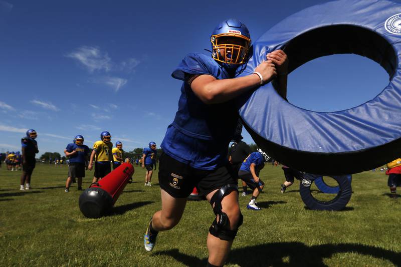 Johnsburg football player Jacob Welch lifts a donut pad as he practices tackling during summer football practice Thursday, June 23, 2022, at Johnsburg High School in Johnsburg.