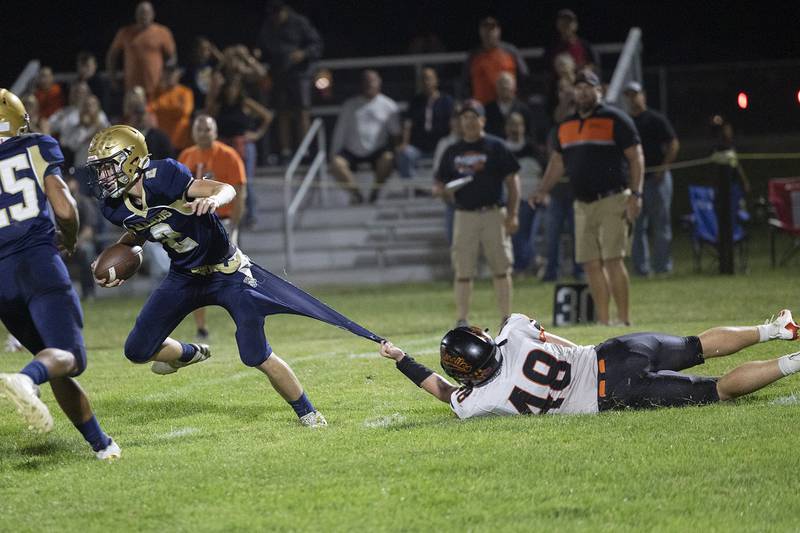 Milledgeville’s Karter Livengood hangs on to Polo’s QB JT Stephenson Friday, Sept. 19, 2025.