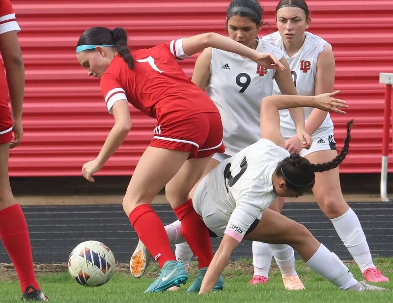 Ottawa's Georgia Kirkpatrick kicks the ball away from L-P defenders Vicky Tejada, Sofia Nanez and Kendal Bassett on Monday, April 13, 2026 on King Field at Ottawa High School.