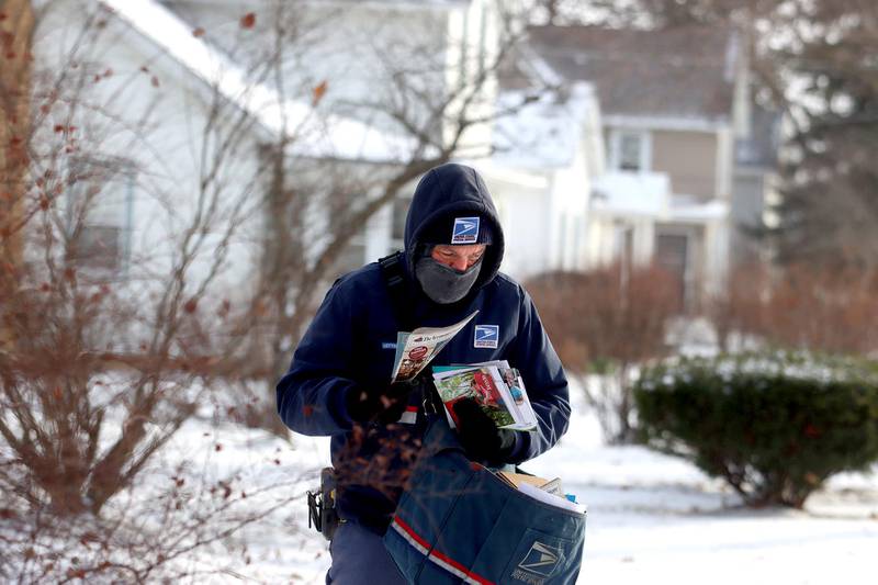 Carrier Mike Driver of the United States Postal Service makes deliveries along Washington Street in Marengo on Friday.