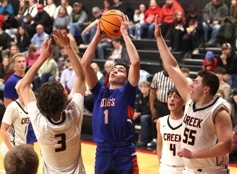 Genoa-Kingston's Marcus Johnson shoots between Indian Creek's Logan Schrader (left) and Payton Hueber during their game Friday, Jan. 3, 2025, at Indian Creek High School in Shabbona.