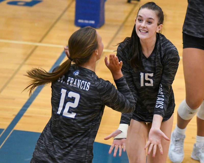 St. Francis teammates Delaney Zamis (15) and Jenna Glaudel (12) celebrate after scoring a point in the first game of the match on Wednesday Oct. 2, 2024, while taking on St. Charles North at St. Francis High School in Wheaton.