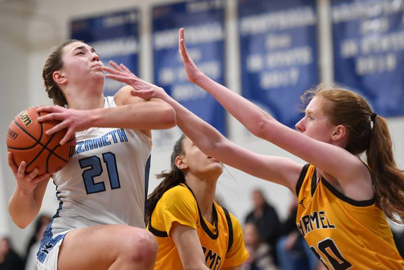 Nazareth's Olivia Austin (21) goes to the basket as Carmel's Keira Ackerson defends during the ESCC conference tournament championship game on Feb. 4, 2023 at Nazareth Academy in LaGrange Park.