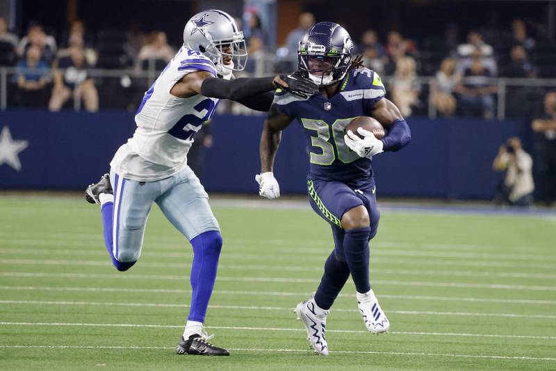 Dallas Cowboys cornerback Nahshon Wright (25) reaches out to stop Seattle Seahawks running back Darwin Thompson as he carries the ball in the second half of a preseason NFL football game in Arlington, Texas, Friday, Aug. 26, 2022. (AP Photo/Michael Ainsworth)