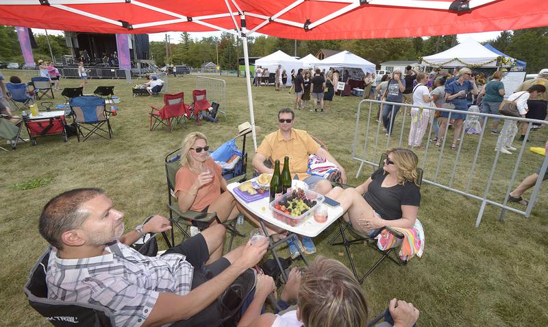 With full table of food and wine, this group enjoys the many comforts of home during the Vintage Wine Festival Saturday at Carey Memorial Park in Utica.