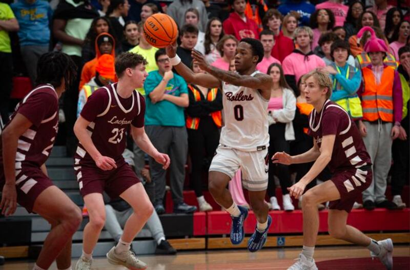 Bradley-Bourbonnais' Ty Dangerfield, center, passes off the ball as he is guarded by Lockport's Collin Miller, center left, and Nedas Venckus, right, during Friday night's game at BBCHS.