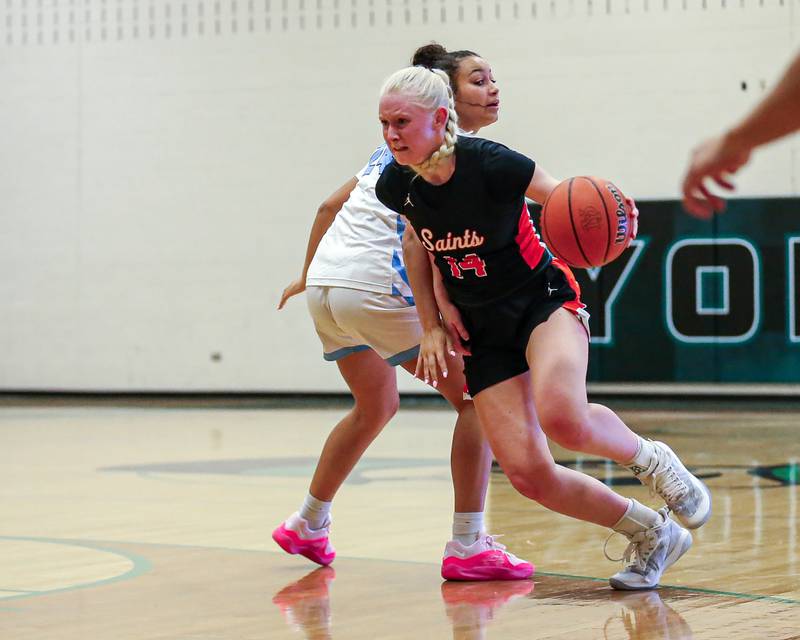 St Charles East's Addie Schilb (14) drives around the defense of Prospect's Campbell Conner (24) at the York Thanksgiving Tournament. Nov 13, 2023.