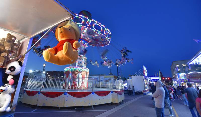 Carnival rides and games attract people to Liberty Drive at the Cream of Wheaton summer festival in downtown Wheaton on Thursday, May 30, 2024.