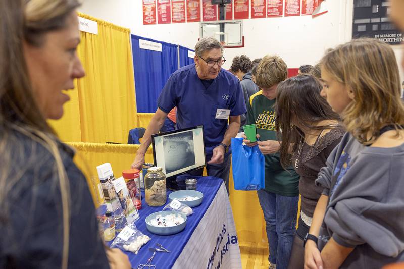 Kristin Loy (left) and Bob Ebbesmeyer of the Northern Illinois Veterinary Medical Association show eighth graders X-rays and necrotic samples Friday, Oct. 17, 2025, during a career fair at SVCC.