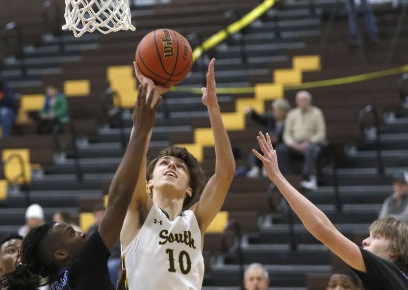 Crystal Lake South's Cam Miller drives to the basket between Larkin’s Adrian York and Jack Casebeer during a Hinkle Holiday Classic basketball game Wednesday, Dec. 28, 2022, at Jacobs High School in Algonquin.