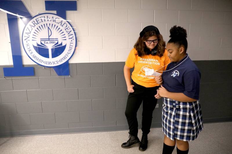 Nazareth Academy student leader Roxanne Stasch (left) helps freshman Arielle Gurley navigate her schedule during freshman orientation at the La Grange Park school on Thursday, Aug. 17, 2023.
