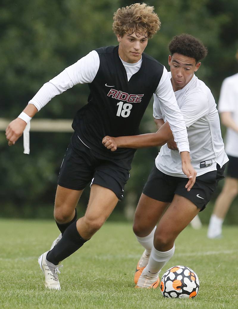 Prairie Ridge's Henry Knoll tries to get into scoring position as he is defended by Hampshire's Evan Amagasse during a Fox Valley Conference soccer match Tuesday, Sept. 19, 2023, at Prairie Ridge High School in Crystal Lake.