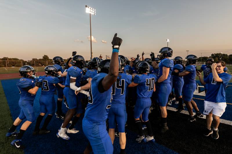 Lincoln-Way East’s varsity football team celebrates during the varsity football game against Metea Valley at Lincoln-Way East on Oct. 3, 2025 after Jonas Williams broke the state passing touchdown record.