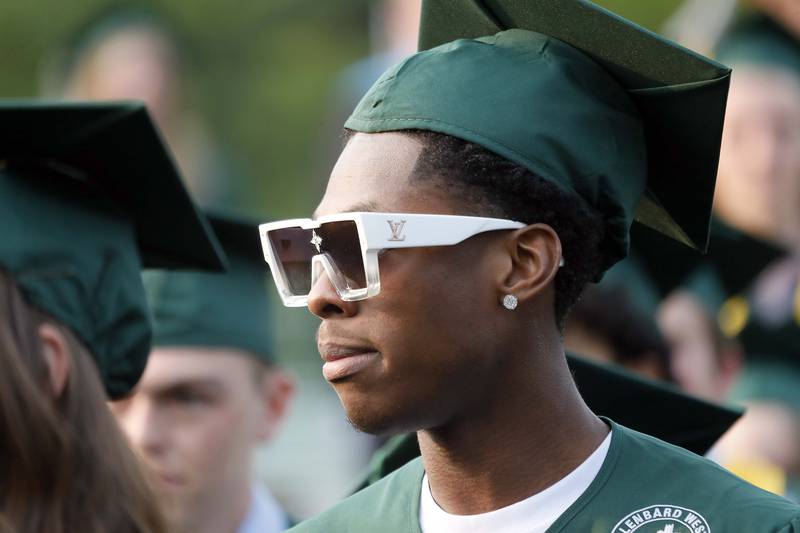 A young man sports some Louis Vuitton sunglasses as he enters the Glenbard West commencement ceremony Thursday May 18, 2023 on Duchon Field in Glen Ellyn.