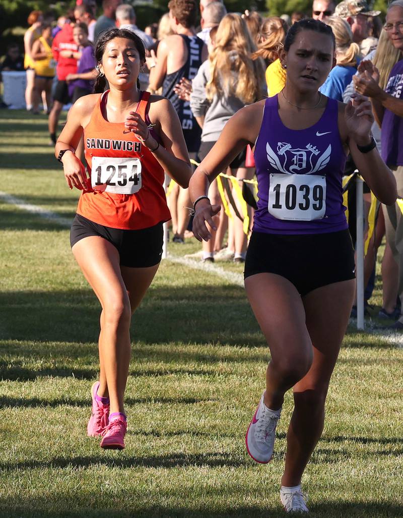 Sandwich’s Joanna Rivera (left) finishes the girls varsity race Tuesday, Sept. 3, 2024, at the Sycamore Cross Country Invite at Kishwaukee College in Malta.