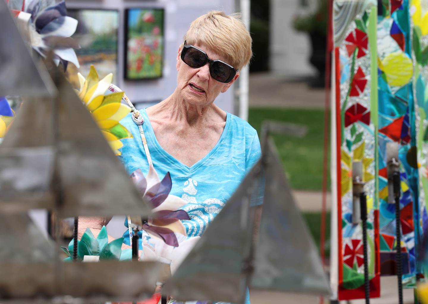 Carolyn Hill, from Geneva, checks out some of the work by artists Janice and Rick Moore Saturday, July 26, 2025, during the Geneva Arts Fair on Third Street in Geneva.