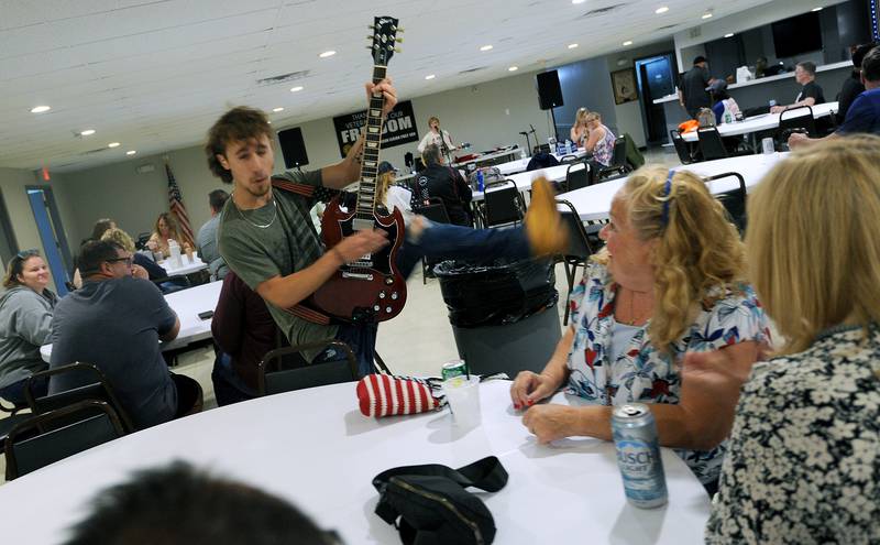 Guitarist Levi Cull, of the Ripped Jeans Duo, fires off a high leg kick while roaming tables during a smaller Fun Fest, due to Sunday morning's rain, on May 26, 2024, at the Yorkville American Legion Post 489.