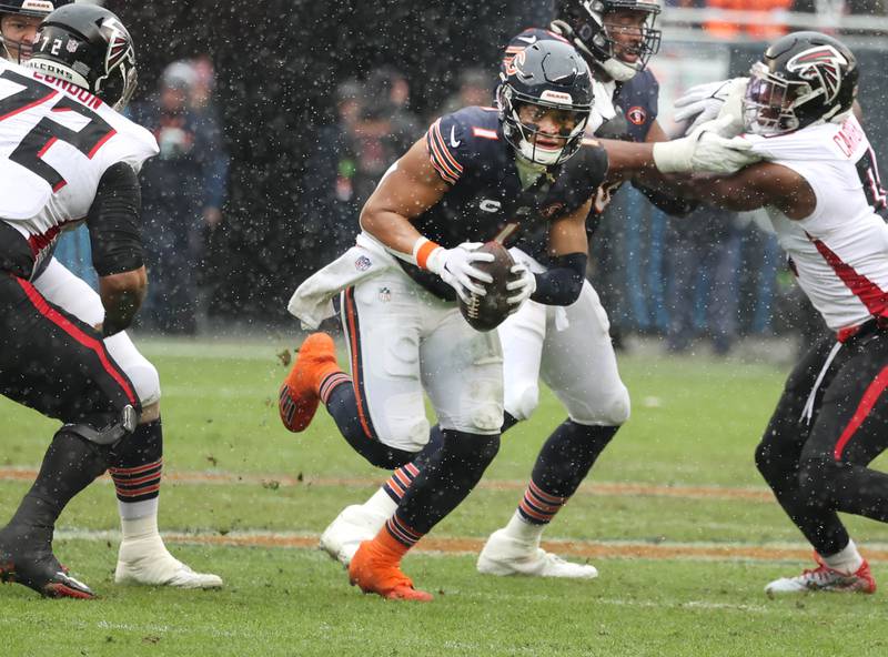 Chicago Bears quarterback Justin Fields avoids the Atlanta Falcon pass rush and picks up yardage during their game Sunday, Dec. 31, 2023, at Soldier Field in Chicago.