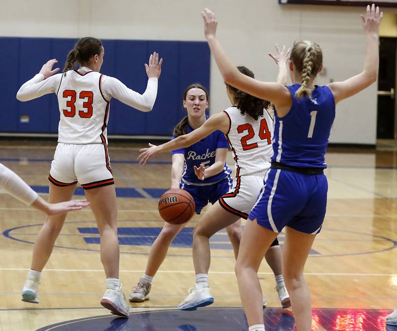 Burlington Central's Audrey LaFleur passes the ball to her teammate, Kenzie Andersen, as she is guarded by Crystal Lake Central's Katie Hamill (left) and Hope Ferrero during the IHSA Class 3A Woodstock Regional Championship girls basketball game on Thursday, Feb. 15, 2024, at Woodstock High School.