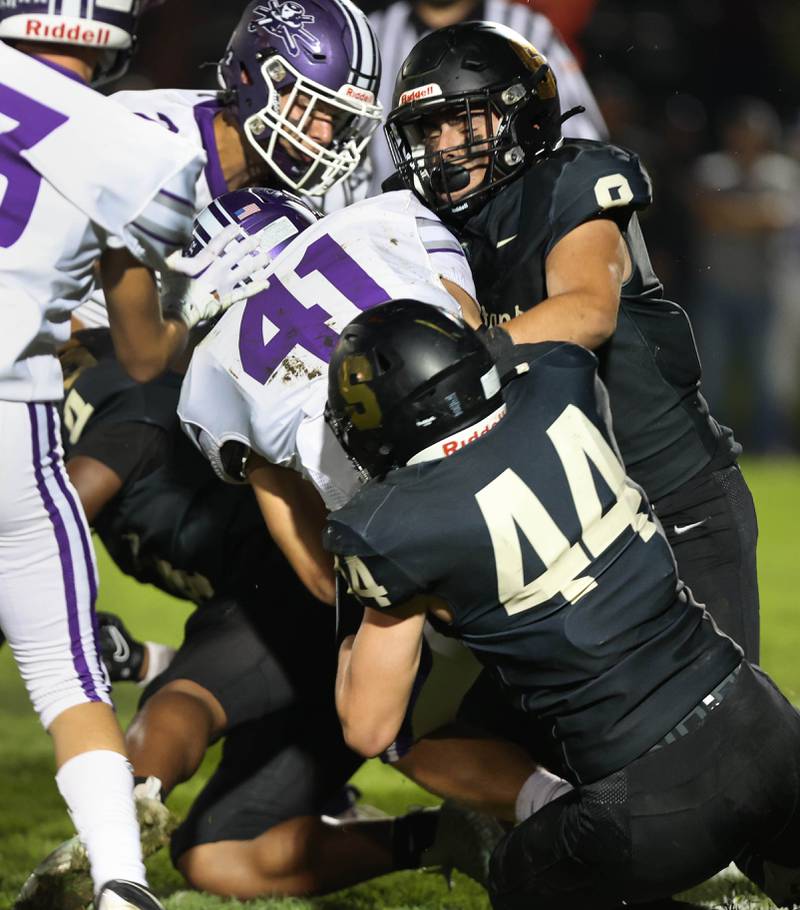 Sycamore's Cooper Bode and Diego Garcia bring down Rochelle's Dylan Manning during their game Friday, Sept. 22, 2023, at Sycamore High School.